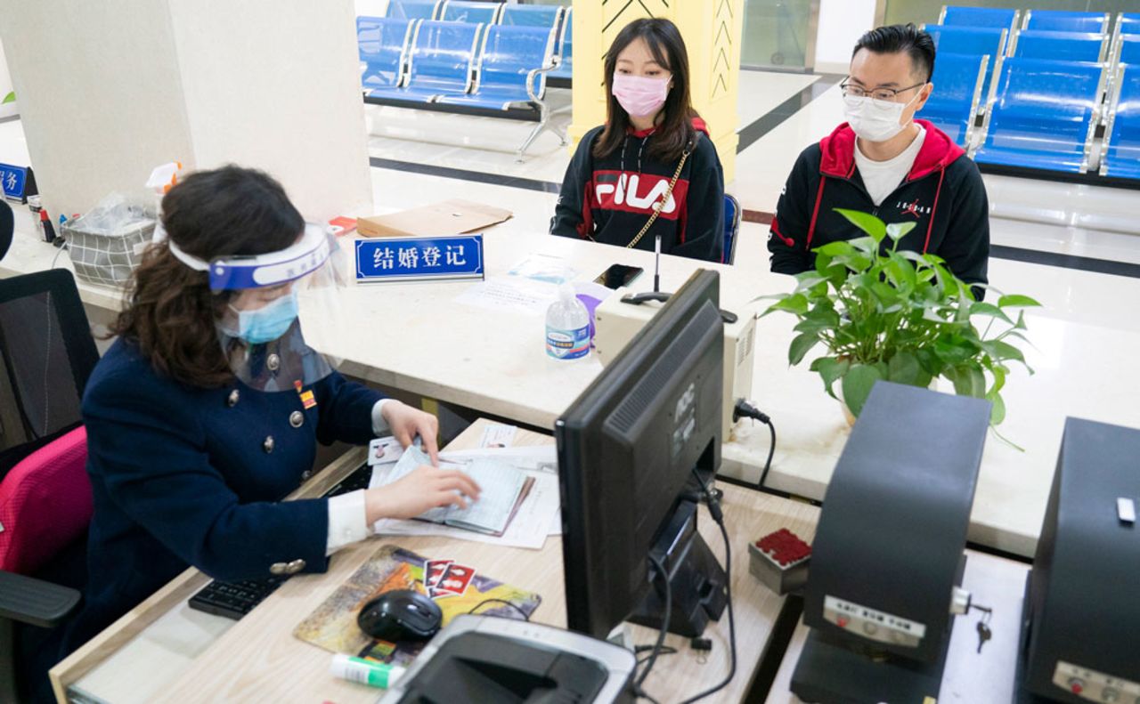 A couple go through marital procedures at a marriage register office in Wuhan, central China's Hubei Province, on April 7.