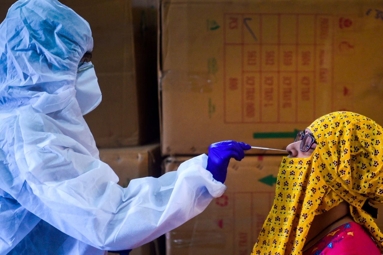 A medical worker takes a swab from a resident of Mumbai, India, for a coronavirus test on September 7.