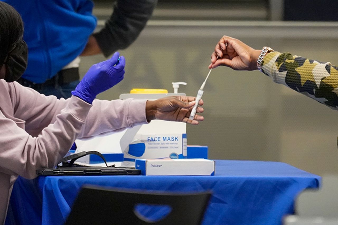 A traveler places a swab in a tube after self testing for COVID-19 at a NYC Health + Hospitals mobile testing site in New York's Penn Station on Nov. 24, 2020.