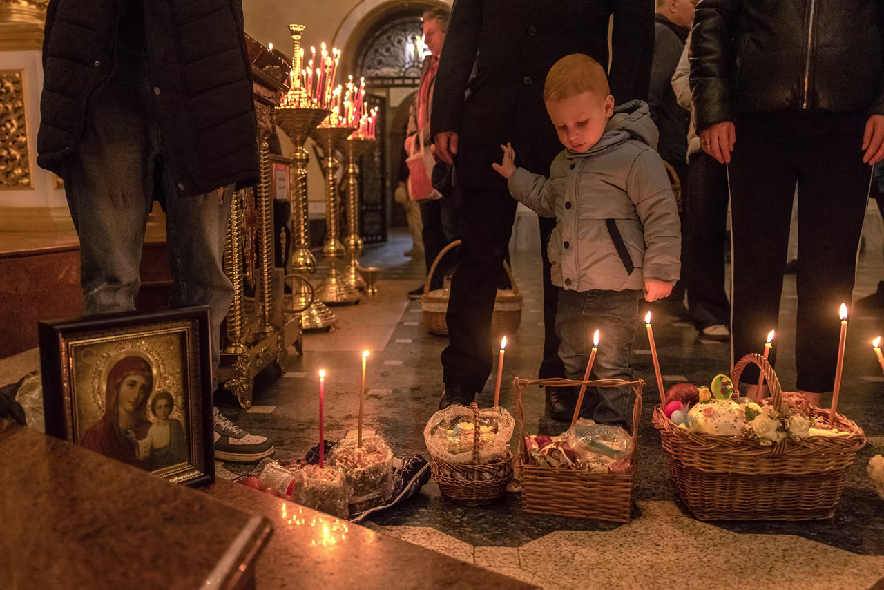 A young boy stands next to Easter baskets at a church in Kyiv, Ukraine, on Sunday.