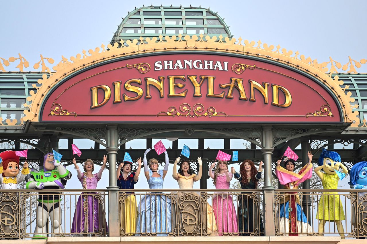 Performers dressed as Disney characters welcome visitors during the reopening of Disneyland Shanghai on May 11 in Shanghai, China.
