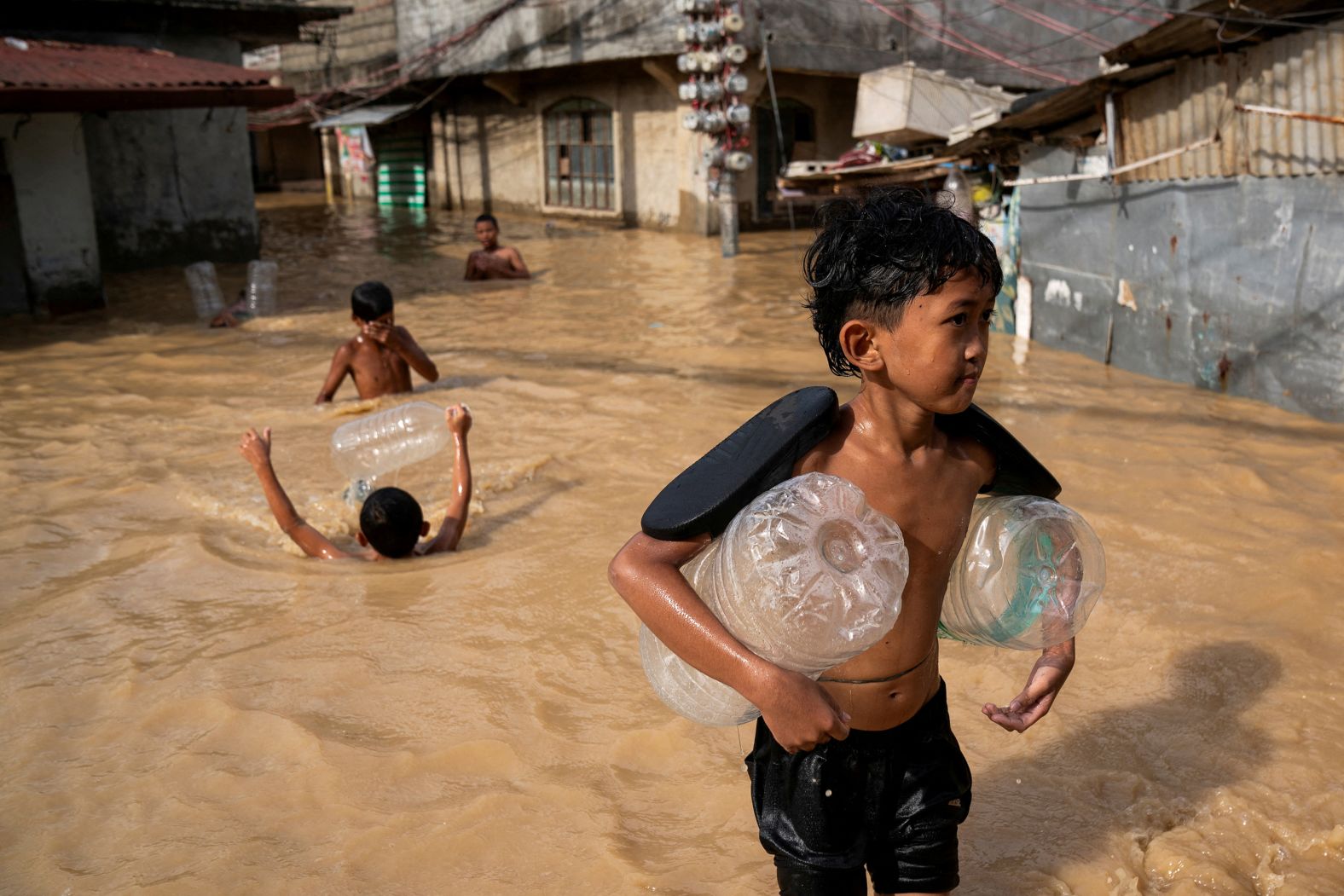 Children play along a flooded street in Cabanatuan, Philippines, on Monday, November 18. Super Typhoon Man-yi, known locally as Pepito, <a href="index.php?page=&url=https%3A%2F%2Fwww.cnn.com%2F2024%2F11%2F16%2Fasia%2Fsuper-typhoon-man-yi-philippines-intl%2Findex.html">ripped through the Philippines’ largest island on Sunday</a>, knocking down houses and sending more than half a million people to emergency shelters. Man-yi is the fourth typhoon to hit the Philippines in less than two weeks.