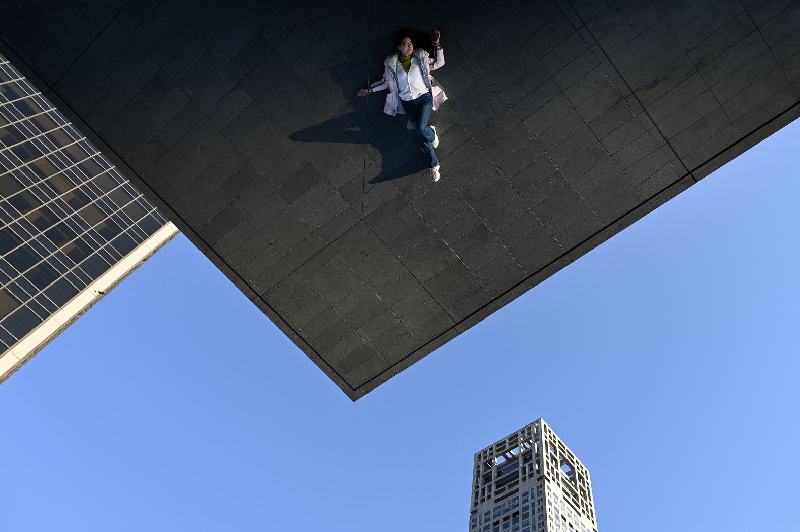 A woman is reflected on the outer wall of a building as she poses for a picture in Beijing on Monday, February 17. <a href="https://www.cnn.com/2025/02/13/world/gallery/photos-this-week-february-6-february-13/index.html">See last week in 32 photos</a>.