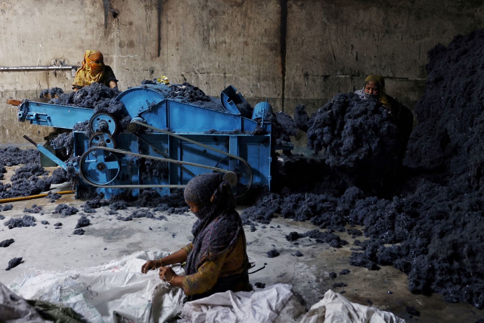 Women in Narayanganj, Bangladesh, work in a factory where fabric waste from garments is transformed into cotton to make mattresses on Wednesday, February 5.