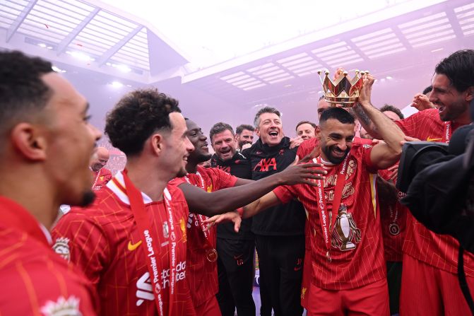 Liverpool star Mohamed Salah has the lid of the Premier League trophy put on his head as he and his teammates celebrate their title in Liverpool, England, on Sunday, May 25.