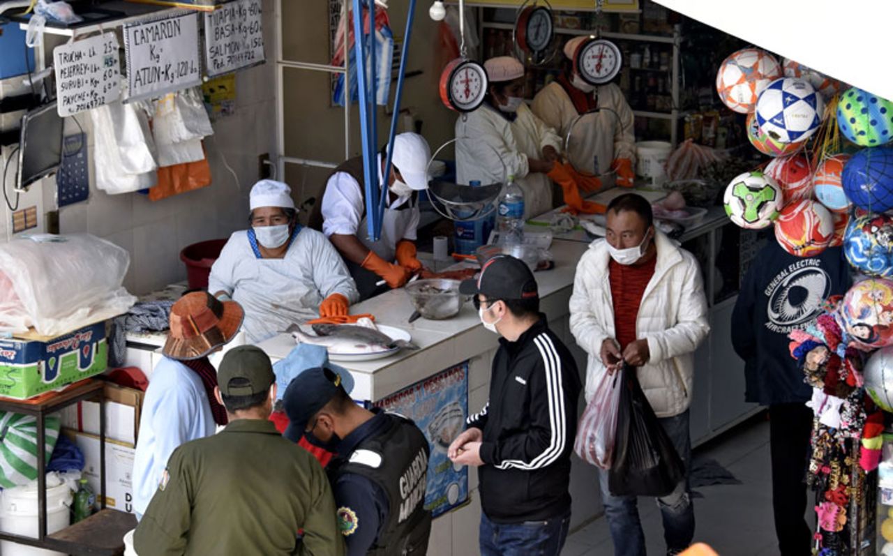 Workers and customers wear face masks as a preventive measure against the spread of the coronavirus at a market in La Paz on March 24.