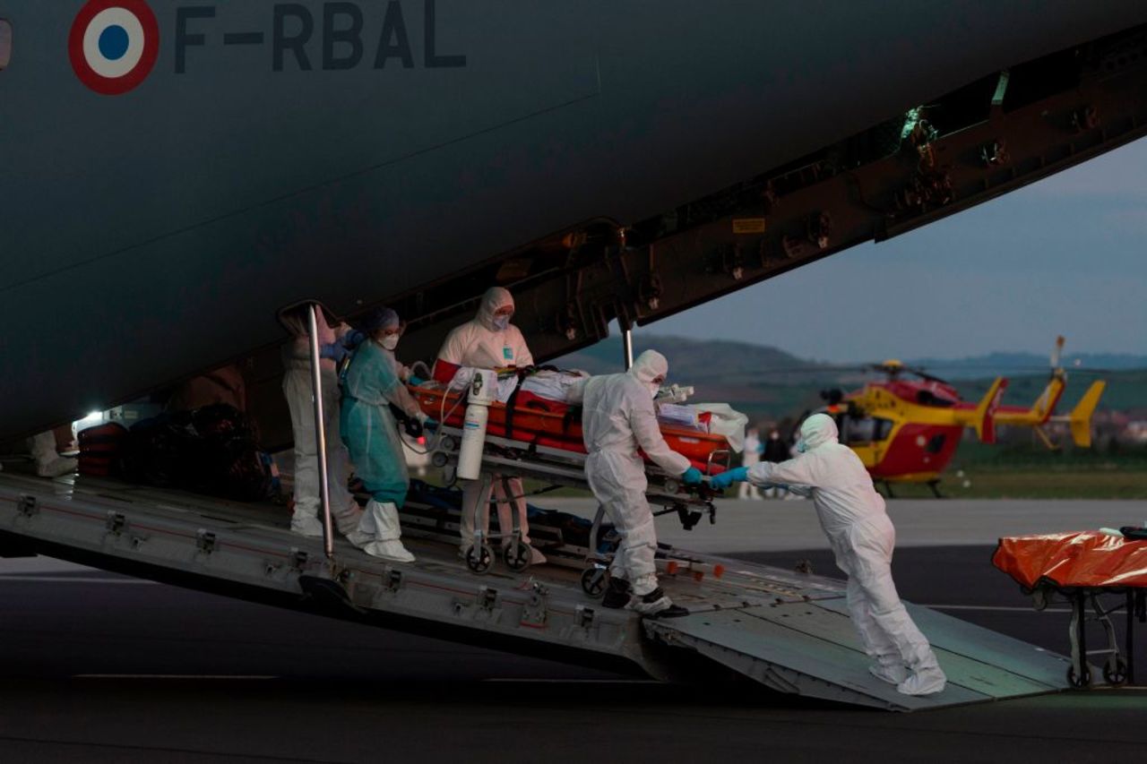 Medical staff carry a patient infected with the novel coronavirus at Aulnat airport, near Clermont-Ferrand, on April 3.