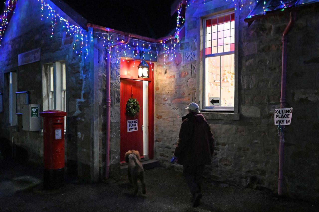 A man with a dog arrives to vote at a polling station in Furnace, Scotland. Photo: Paul Ellis/AFP via Getty Images 