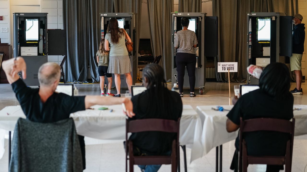 A Fulton County Elections worker stretches his arms as voters cast ballots in Georgia's primary election at a polling location in Atlanta, Georgia on May 21, 2024. 