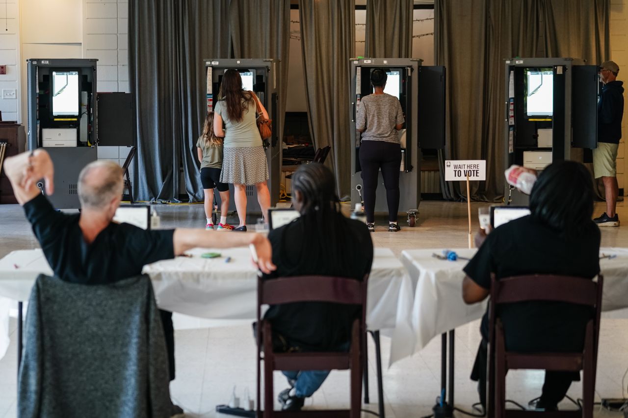 A Fulton County Elections worker stretches his arms as voters cast ballots in Georgia's primary election at a polling location in Atlanta, Georgia on May 21, 2024. 