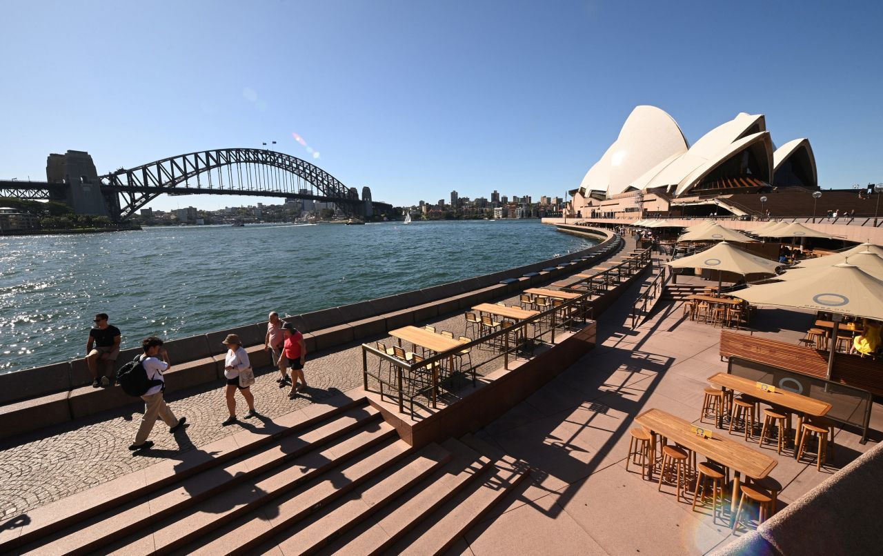 Tourists walk along Circular Quay in Sydney on March 20.