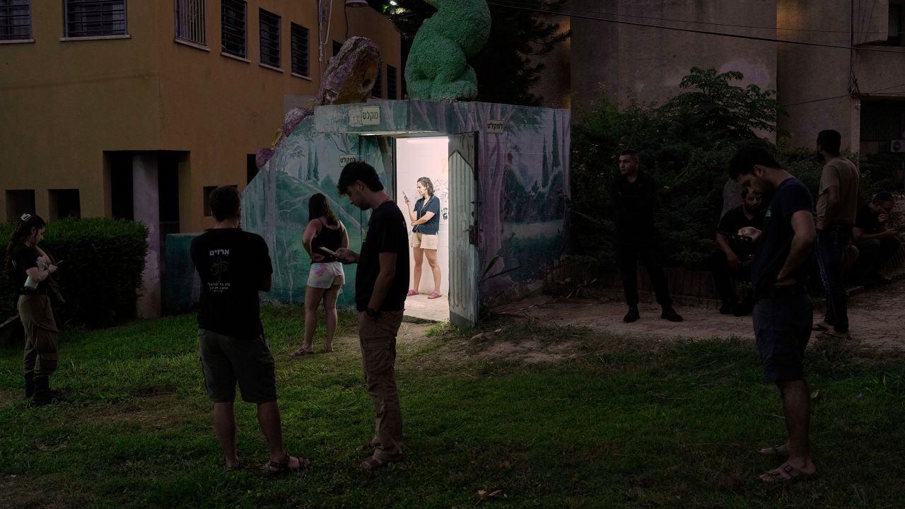 Israeli soldiers and residents gather near a public bomb shelter after receiving a message alerting about an incoming missile launched from Iran, in Holon, central Israel, on Tuesday, June 24, 2025. (AP Photo/Bernat Armangue)