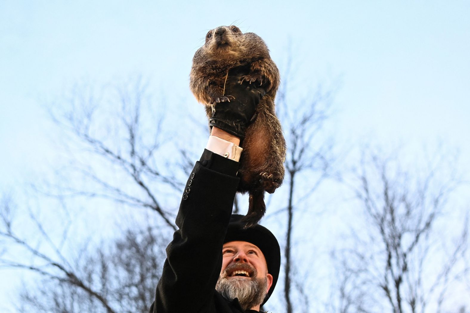 A.J. Dereume holds up Punxsutawney Phil, the famous groundhog weather watcher, in Punxsutawney, Pennsylvania, on Sunday, February 2. Phil was pulled from his warm burrow and <a href="https://www.cnn.com/2025/02/02/weather/groundhog-day-shadow-winter-spring-climate/index.html">saw his shadow</a>, predicting six more weeks of winter.