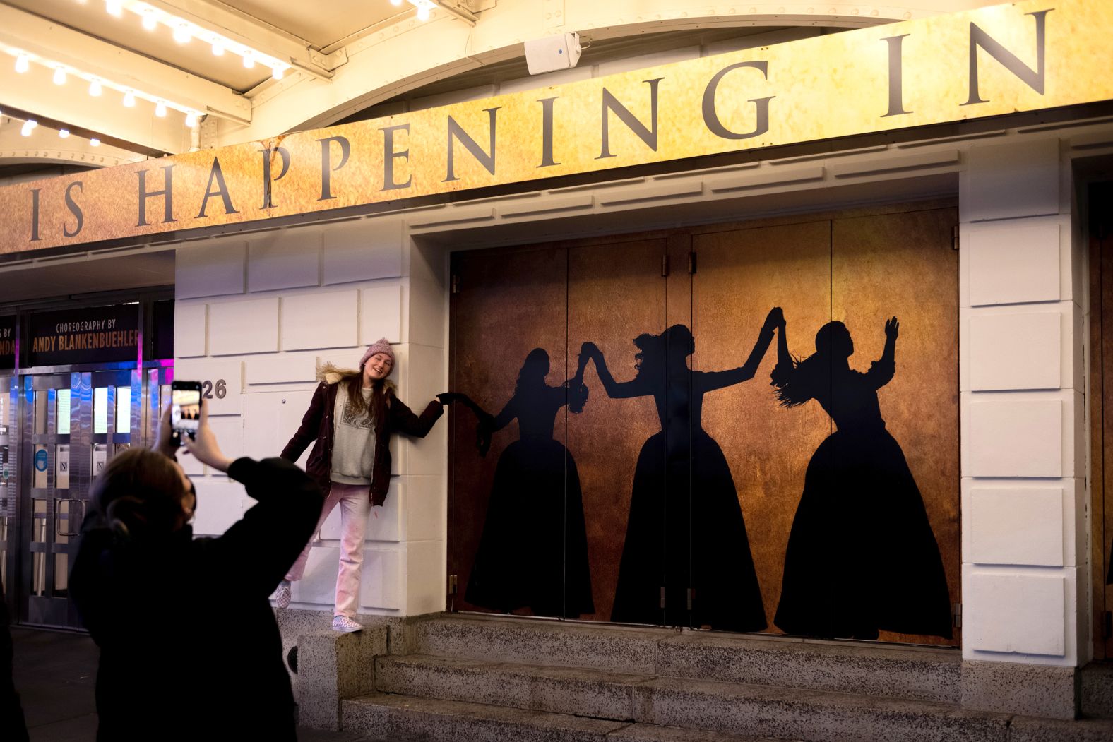 A tourist takes a photo outside the RIchard Rodgers Theatre in December 2021.