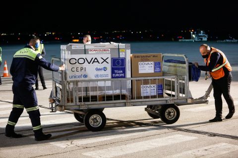 Airport employees push a cart carrying a shipment of AstraZeneca/Oxford Covid-19 vaccines at the Pristina International Airport on March 28. 