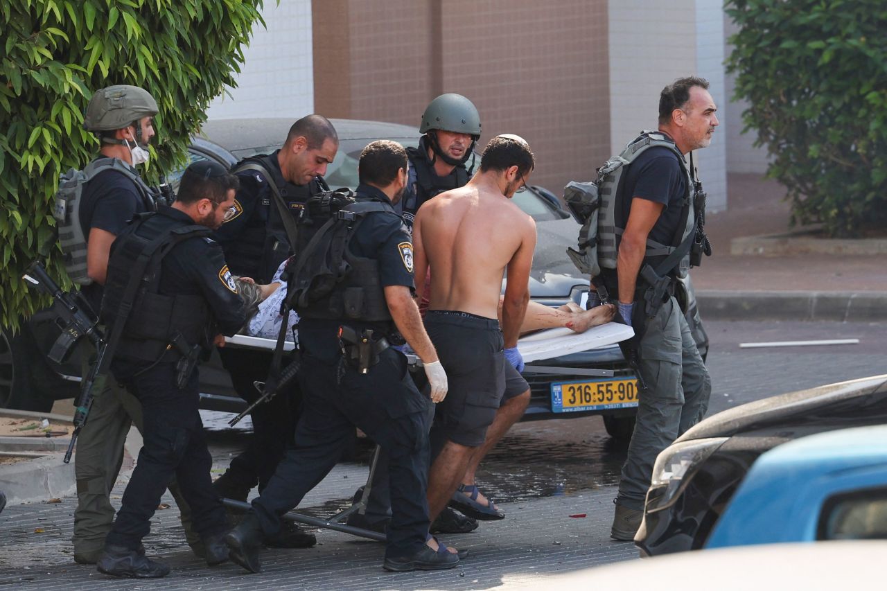 Members of Israeli security forces carry an injured person on a stretcher following a rocket attack from the Gaza Strip in Ashkelon, southern Israel, on October 7, 2023.