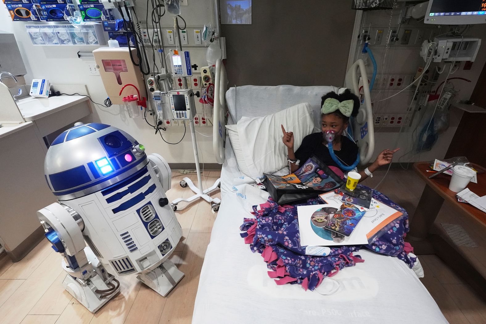 Micah White-Powell dances in her bed as she’s visited by “Star Wars” droid R2-D2 at the Corewell Health Children's Hospital in Royal Oak, Michigan, on Friday, May 2.