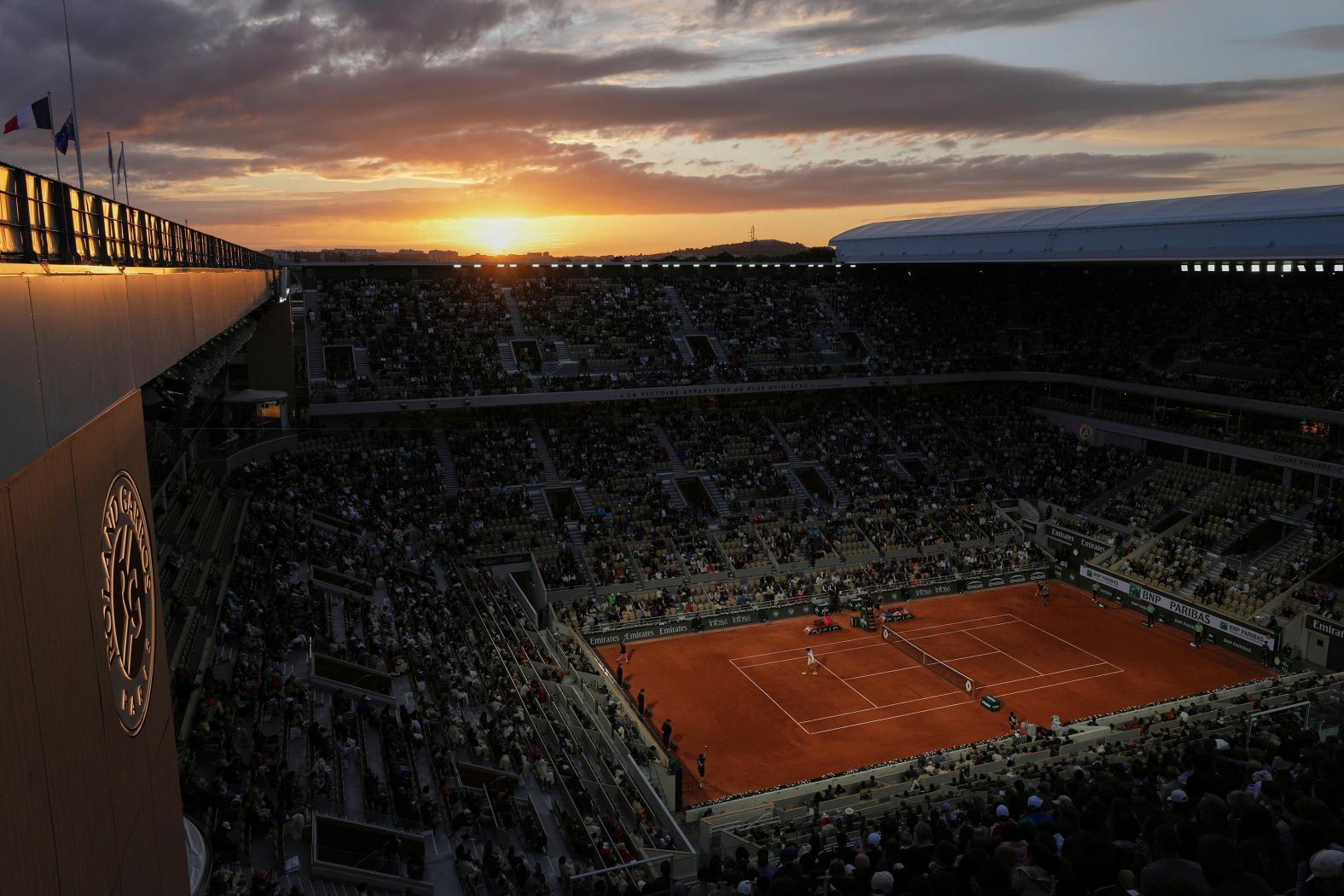 The sun sets in Paris as Ben Shelton and Lorenzo Sonego play a first-round match at the French Open on Sunday, May 25.