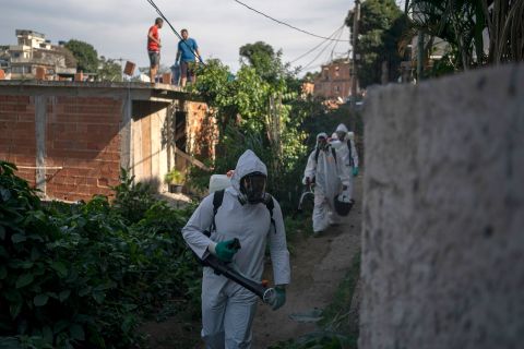 Volunteers spray disinfectant in a Rio de Janeiro alleyway to help contain the spread of the novel coronavirus on Sunday.
