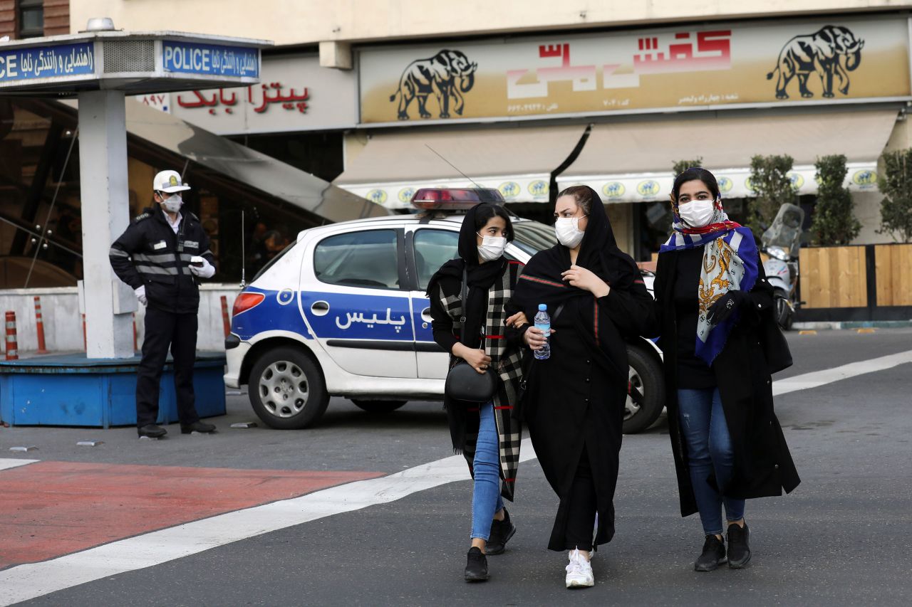 A policeman and pedestrians wear masks to help guard against the Coronavirus in downtown Tehran on February 23.