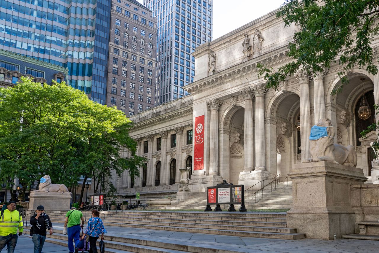 People walk by the New York Public Library in July 2020.