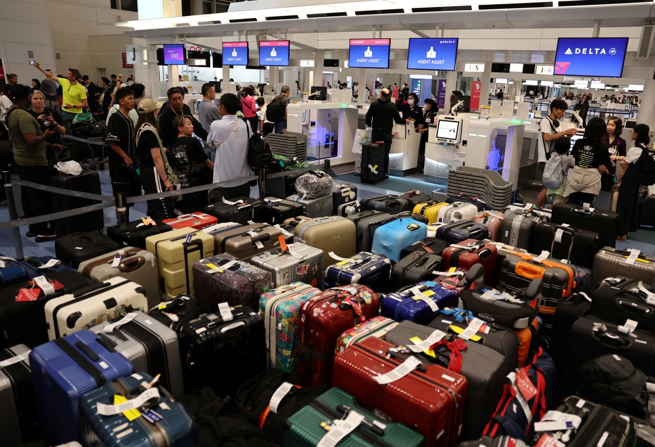 Passengers stand in line at a Delta Air Lines counter at Haneda Airport in Tokyo on July 19.