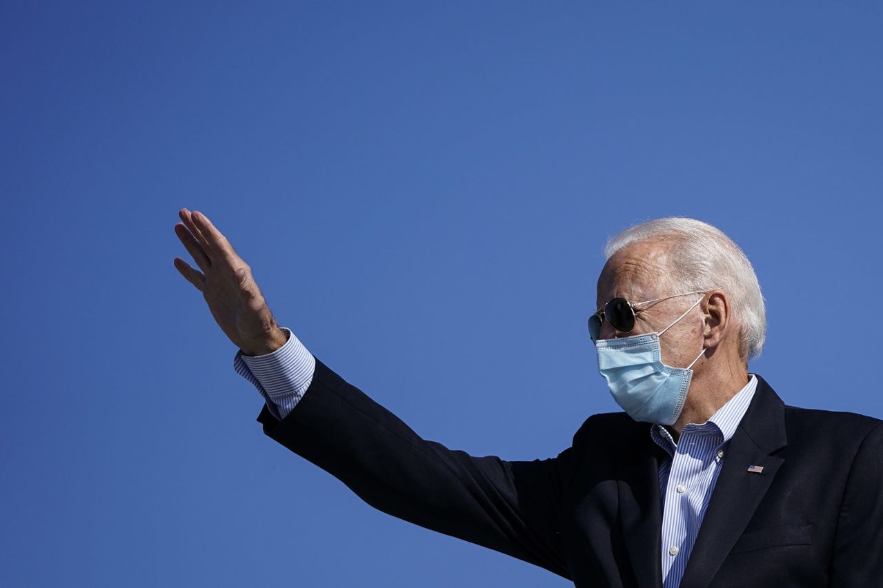 Democratic presidential nominee Joe Biden waves as he boards his campaign plane at New Castle Airport on October 22, in New Castle, Delaware. 