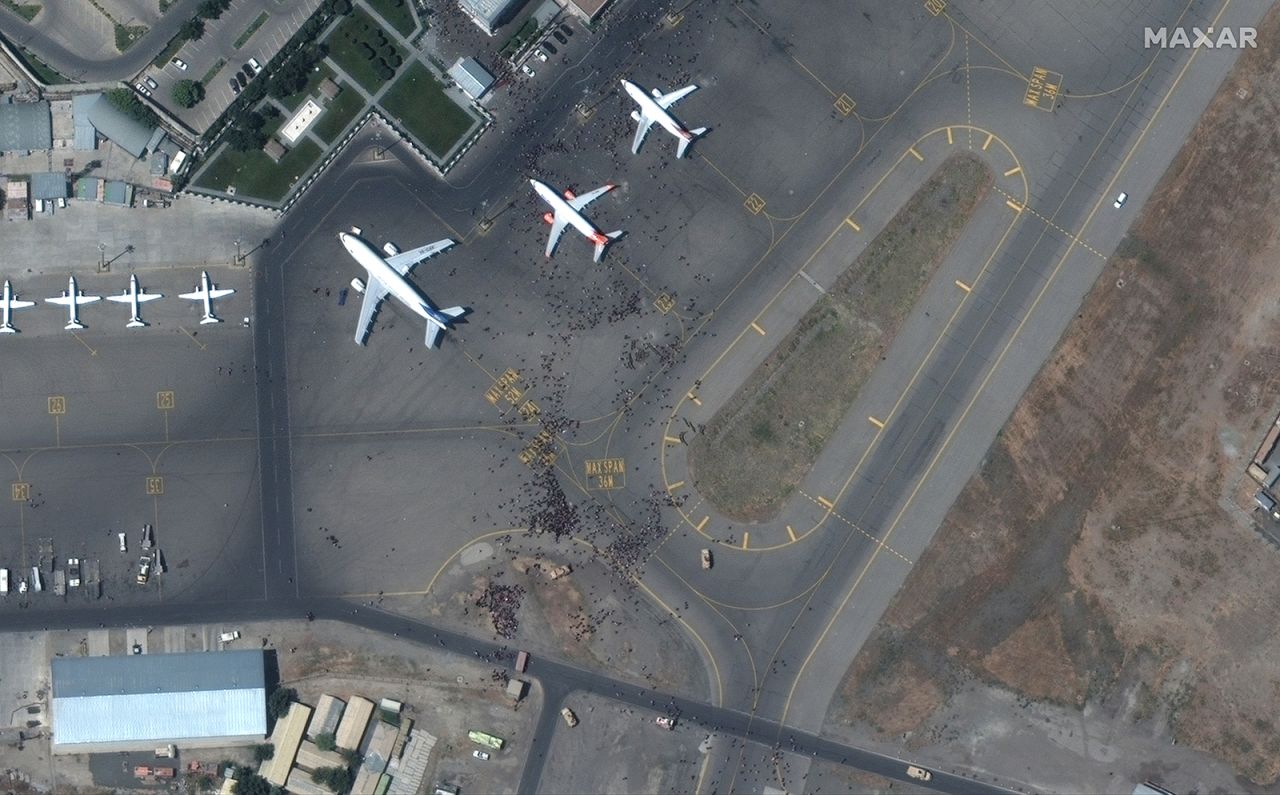 People crowd a tarmac. 