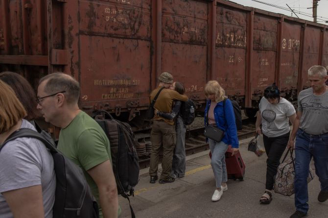 A Ukrainian serviceman kisses his partner after she arrived by train in Kramatorsk, Ukraine, on Saturday, June 15. <a href=