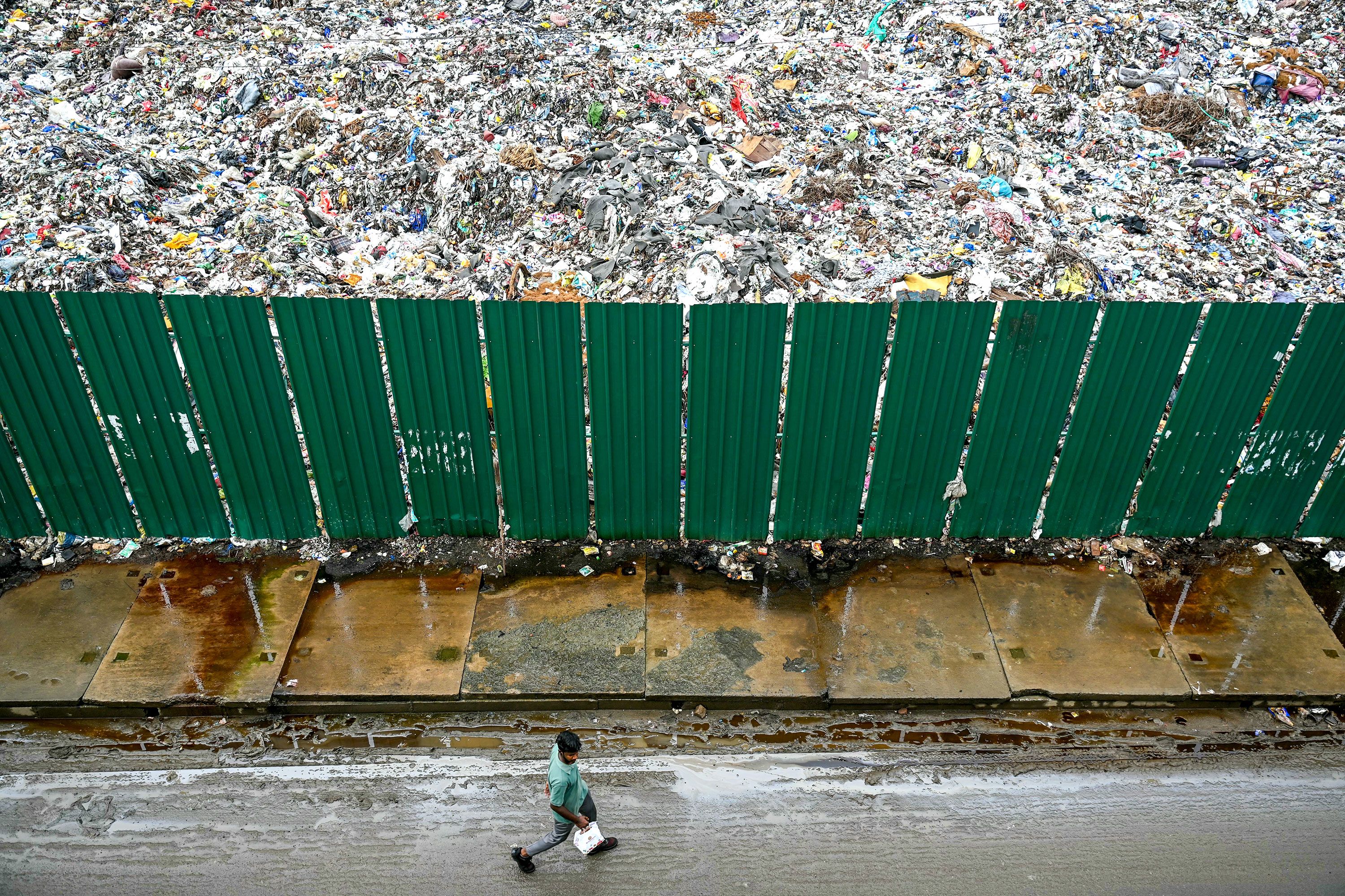 A man walks past a disposal site in Chennai, India, on Monday, July 15.