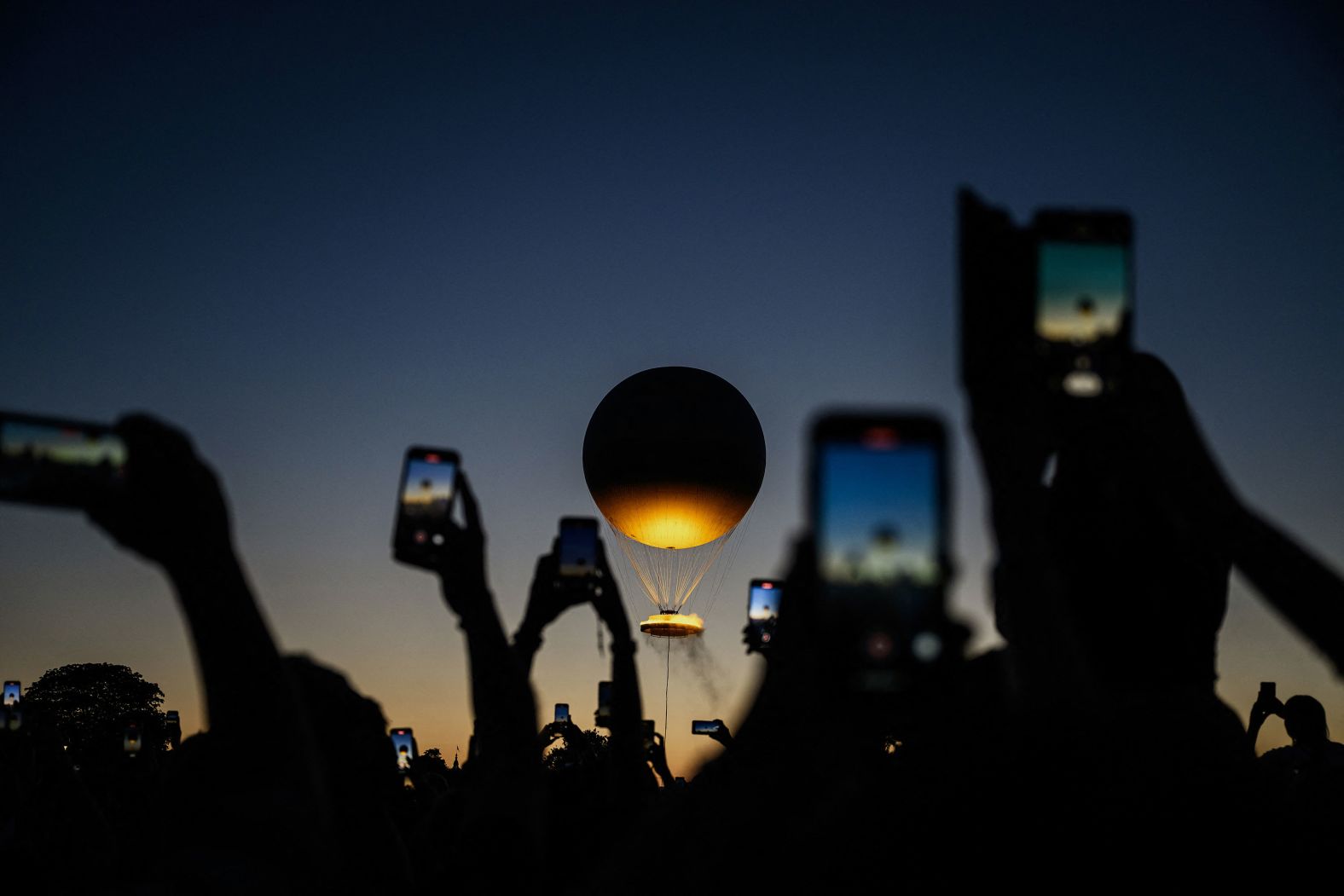 People take pictures of the Olympic cauldron in Paris on Monday, August 5. <a href="index.php?page=&url=https%3A%2F%2Fwww.cnn.com%2F2024%2F08%2F01%2Fworld%2Fgallery%2Fphotos-this-week-july-25-august-1%2Findex.html">See last week in 35 photos</a>.