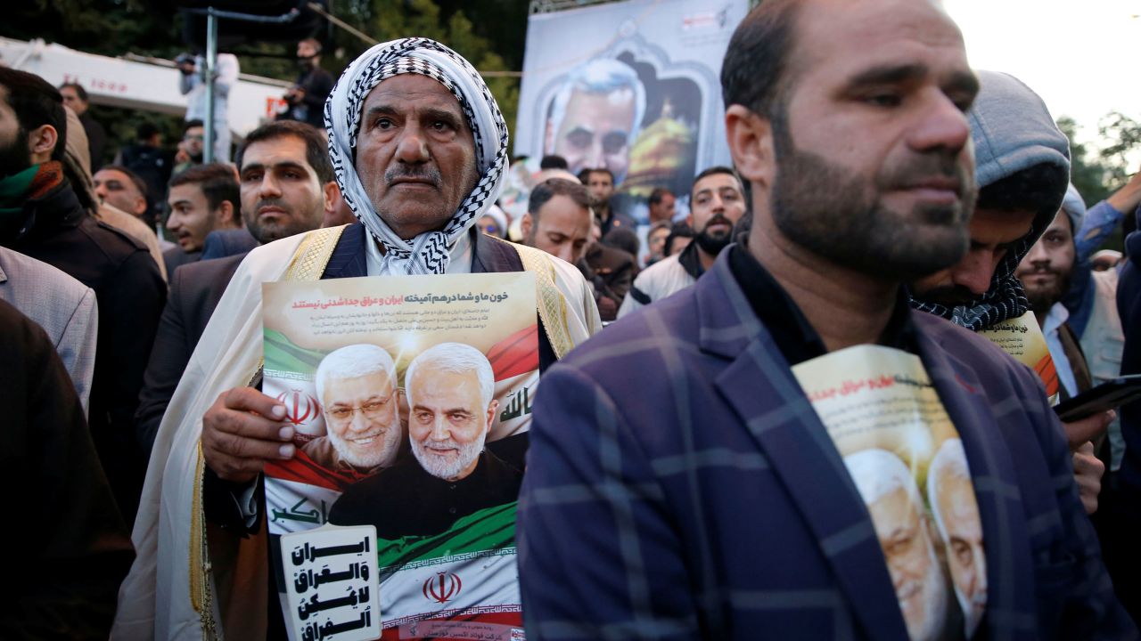 A man holds a picture of the killed officials. 