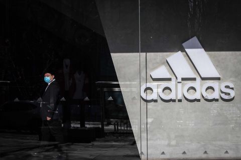 A security guard wearing a protective face mask stands on duty at an Adidas store in Beijing on February 8.