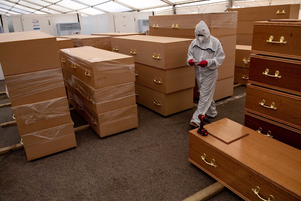 A volunteer walks past coffins in a temporary morgue for coronavirus victims at the Central Jamia Mosque Ghamkol Sharif in Birmingham, England, in April.