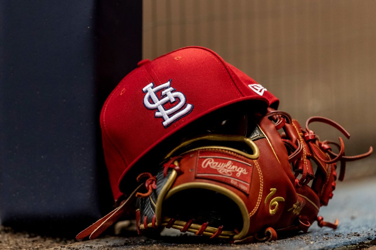 A St. Louis Cardinals hat and glove sit on the dugout step during a MLB game at Miller Park in Milwaukee, Wisconsin, on March 29, 2019.