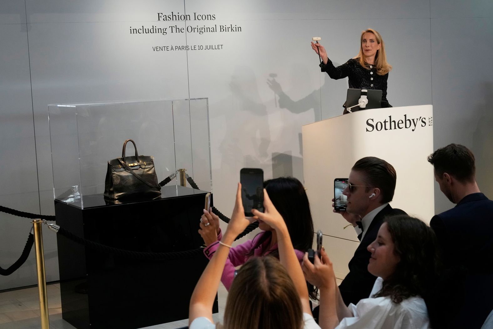 Auction officer Aurélie Vandevoorde gestures as the original Birkin bag, created by Hermès for actor and singer Jane Birkin, <a href="index.php?page=&url=https%3A%2F%2Fwww.cnn.com%2F2025%2F07%2F10%2Fstyle%2Foriginal-hermes-birkin-sells">was sold in Paris</a> for a winning bid of €7 million ($8.2 million). After fees, it came out to €8.6 million ($10 million). It’s the most expensive handbag to ever sell at auction.