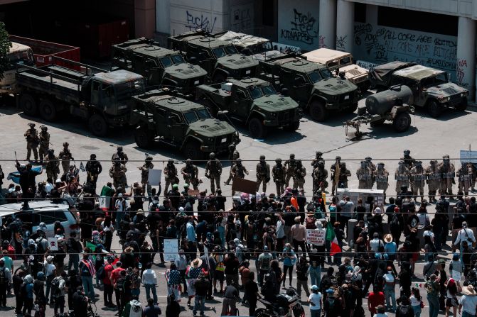Members of the National Guard stand in front of protesters in downtown Los Angeles on Sunday, June 8.