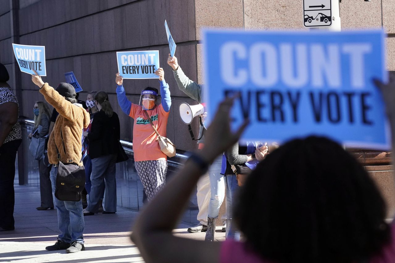 Demonstrators stand across the street from the federal courthouse in Houston, Texas, on Monday, before a hearing in federal court involving drive-thru ballots cast in Harris County. 