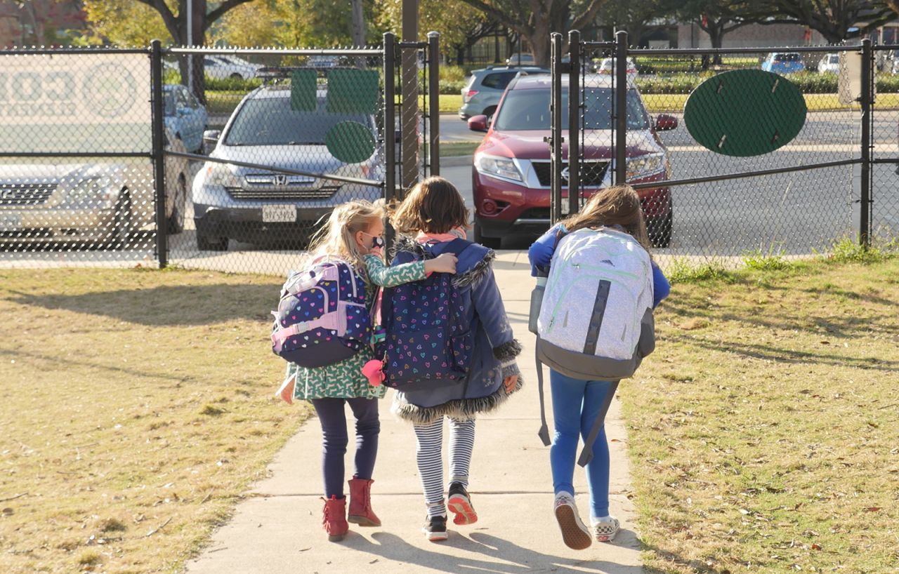 School children wearing facemasks walk outside Condit Elementary School in Bellaire, outside Houston, Texas, on December 16, 2020.