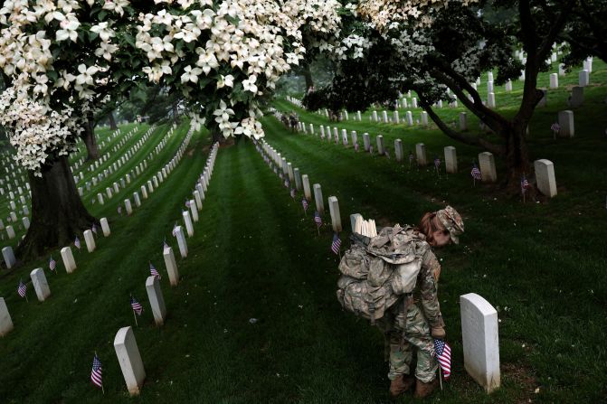 A US Army soldier places flags at Arlington National Cemetery in Arlington, Virginia, on Thursday, May 22.