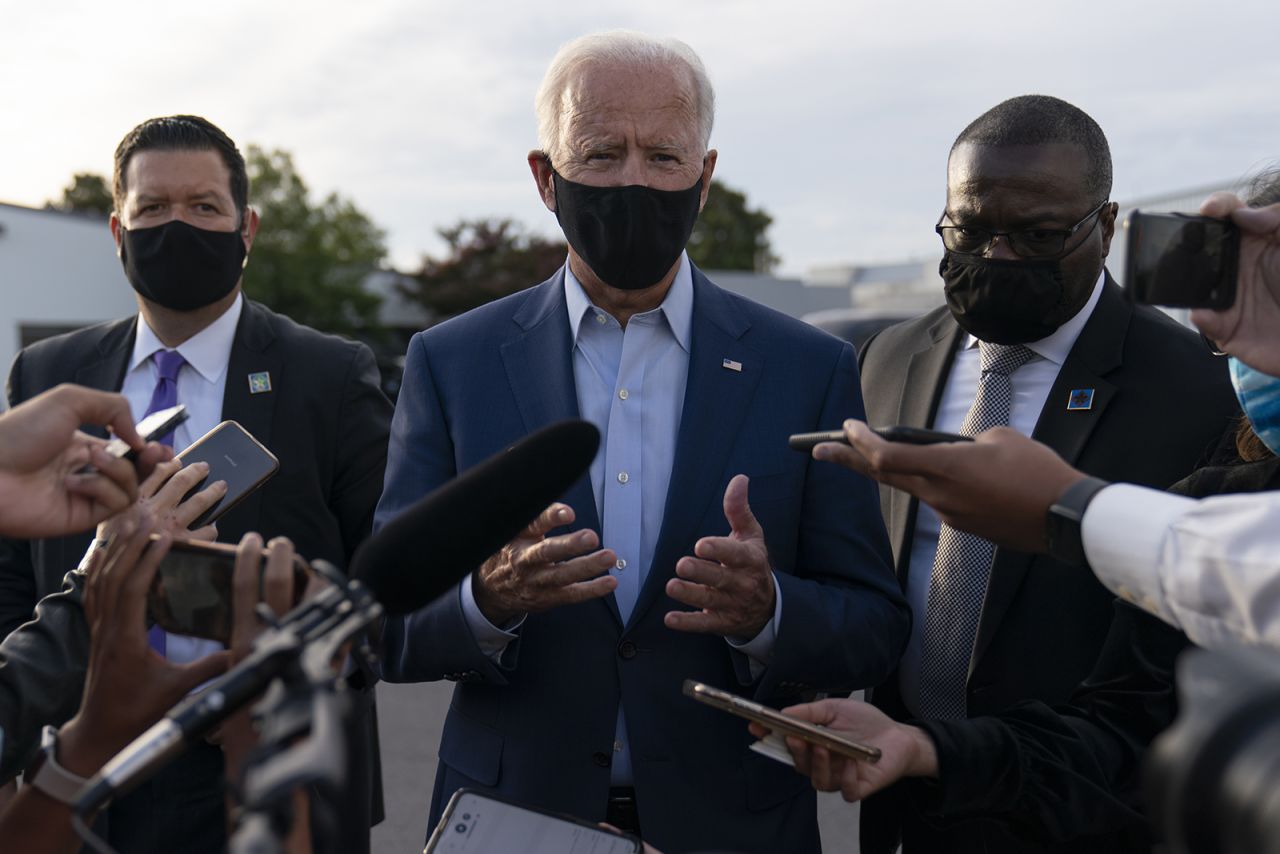 Democratic presidential nominee Joe Biden, flanked by members of his Secret Service detail, speaks to media about the Breonna Taylor ruling and other topics before boards a plane at Charlotte Douglas International Airport in Charlotte, North Carolina on Wednesday.