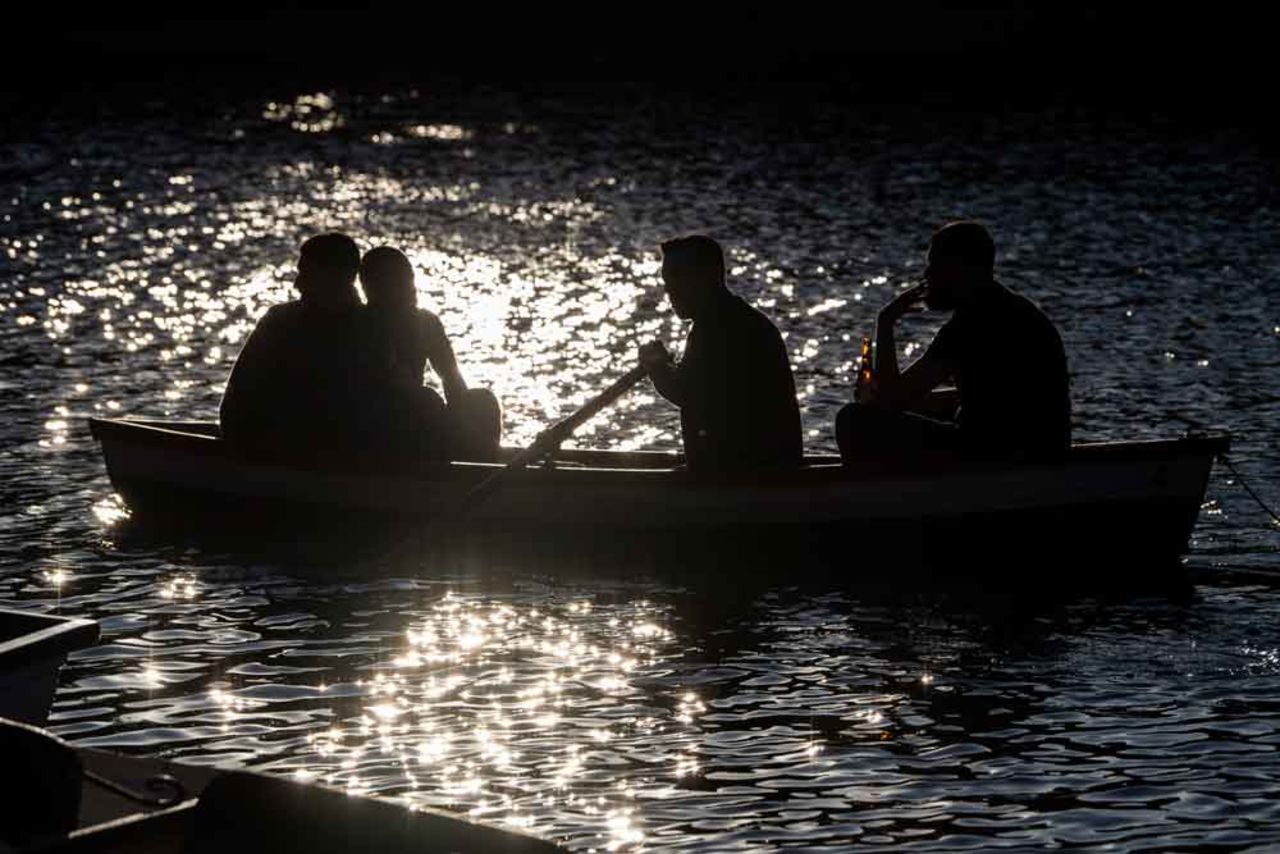 Friends row a boat at Hollow Ponds in East London on May 31 in London, England, after the UK Government eased some coronavirus lockdown restrictions.