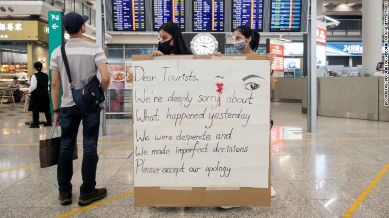 Protesters returned to the airport on Wednesday holding signs apologizing for the violence on Tuesday night.