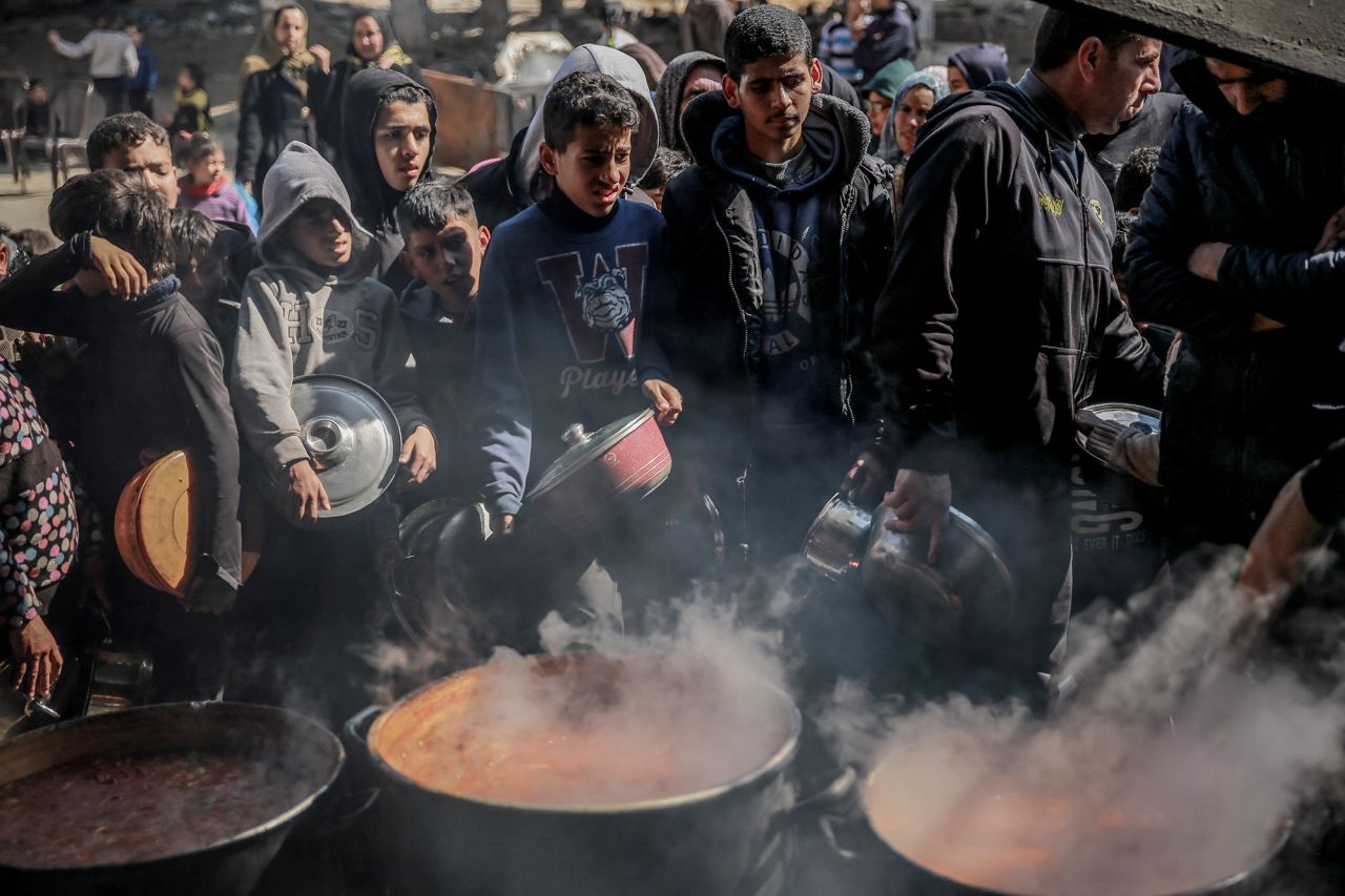 Palestinians gather to collect aid food in Beit Lahia, in the northern Gaza Strip, on February 26.