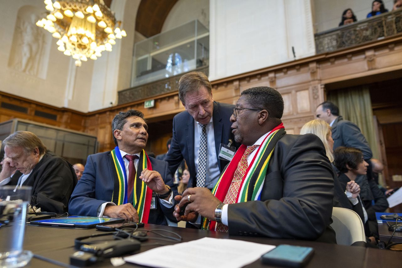 South Africa's Vusimuzi Madonsela, seated right, and Cornelius Scholtz, seated second left, talk prior to the start of hearings at the International Court of Justice, in The Hague, Netherlands, on May 16.