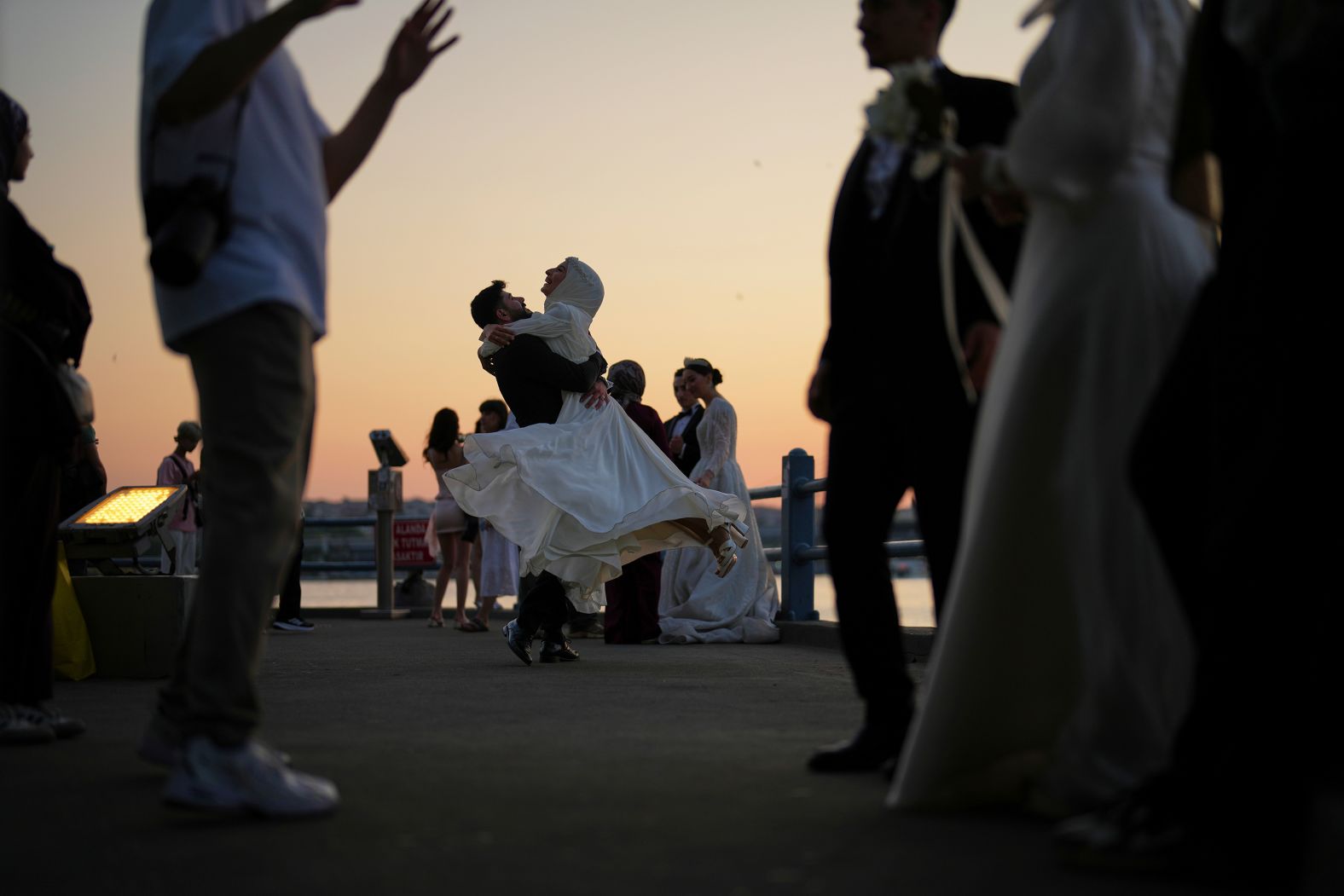 A couple wearing wedding outfits dances during a photo session at the Galata Bridge in Istanbul on Friday, June 13. <a href="index.php?page=&url=https%3A%2F%2Fwww.cnn.com%2F2025%2F06%2F12%2Fworld%2Fgallery%2Fphotos-this-week-june-5-june-12">See last week in 38 photos</a>.