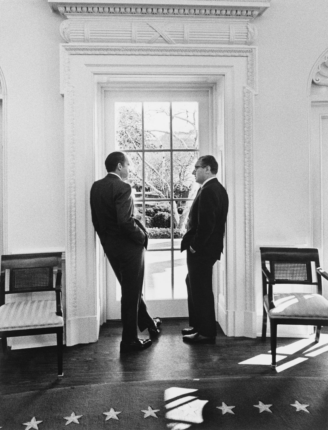 President Richard Nixon and Henry Kissinger stand at an Oval Office window on February 10, 1971.