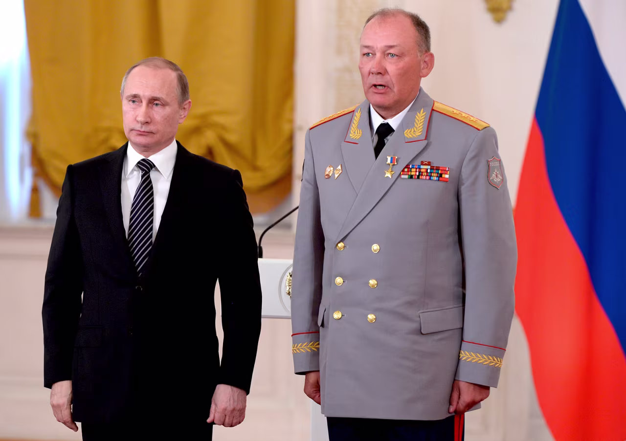 In this pool photo taken on Thursday, March 17, 2016, Russian President Vladimir Putin, left, poses with Col. Gen. Alexander Dvornikov during an awarding ceremony in Moscow's Kremlin, Russia.