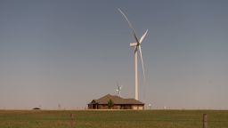 Wind turbines tower above a home in Weatherford, Oklahoma, in April 2022.