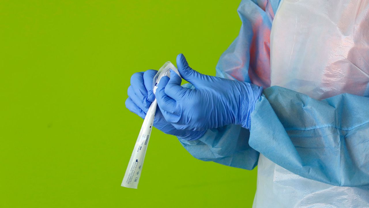 In this photo taken on April 6, a health care worker holds a sample from testing in Palma, Spain. 